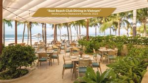 后川Melia Ho Tram Beach Resort的一间带桌椅和海滩的餐厅