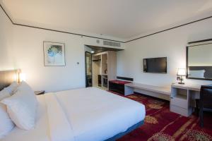 山打根沙巴大酒店的酒店客房设有一张大床和一台电视。