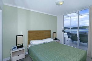 艾塔龙海滩Ettalong Beach Luxury Apartments的一间卧室配有一张床,享有海景