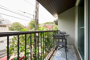 清迈Teera villa chiang mai ทีร่าวิลล่าเชียงใหม่的阳台配有2把椅子和桌子