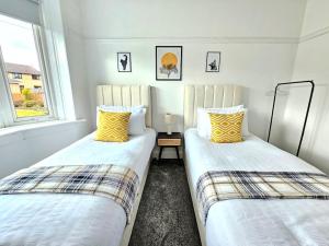格拉斯哥Charming 3-Bed Oasis-free parking的两张睡床彼此相邻,位于一个房间里