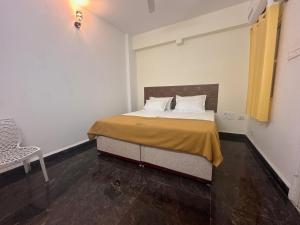 蒂鲁瓦纳马莱MPS Sai Palace的一间卧室配有一张床和一把椅子