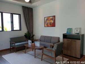 西哈努克Ream YoHo Resort的带沙发、椅子和桌子的等候室