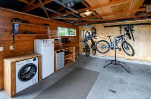 罗托鲁瓦Aura @ Home的车库配有洗衣机,墙上有两辆自行车