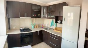 比什凯克Elegant 3-room apartment near iMall: Kievskaja Street的厨房配有棕色橱柜和白色冰箱