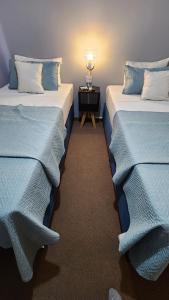 门多萨Essencial Hotel & Spa的两张睡床彼此相邻,位于一个房间里