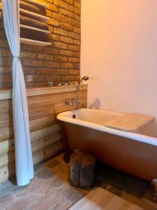 CsesztveNature Lodge Csesztve的带浴缸的浴室和砖墙
