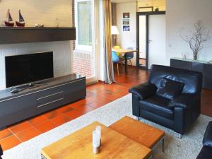 朗格奥Christel Modern retreat的客厅配有黑色真皮沙发和电视