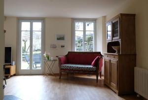 施皮茨Erica的客厅设有红色的沙发和窗户。