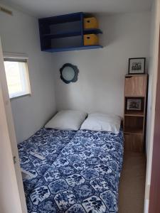 LombezMobilhome cosy au calme de la campagne的一间卧室配有一张带蓝色和白色被子的床