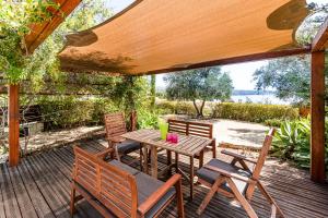 珊瑚湾Villa Demiana by Ezoria Villas的木制甲板上的木桌和椅子