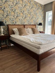 哈尔姆斯塔德Hotell Toftalund的卧室内的一张床位,配有花卉壁纸