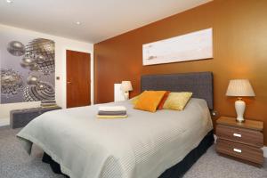 伦敦Dennison House的一间卧室配有一张带橙色枕头的大床