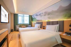 深圳深圳福田华强北秋果酒店的一间酒店客房,设有两张床和电视