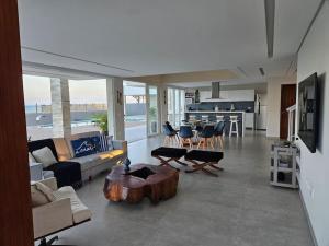 Barra do SirinhaémBeira mar com vista espetacular! Quinta da Barra!的带沙发和咖啡桌的客厅