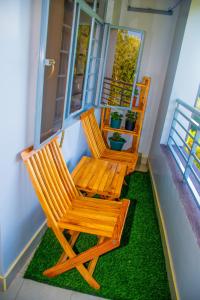 OthayaOthaya Hideout的两把木椅,坐在带草门廊上