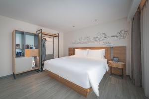 南京南京新街口逸扉酒店的卧室配有一张白色大床和镜子
