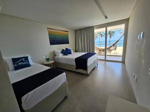 Barra do SirinhaémBeira mar com vista espetacular! Quinta da Barra!的一间带两张床的卧室,享有海景