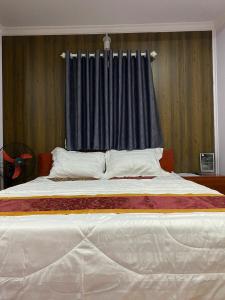 Bạc LiêuMotel Nhật Quang(HẢO BÙI)的一间卧室配有一张带蓝色窗帘的大床