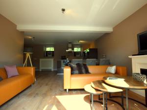 斯莱纳肯Stunning Holiday Home near Forest in Slenaken的客厅配有橙色沙发和桌子