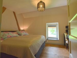 斯莱纳肯Stunning Holiday Home near Forest in Slenaken的一间卧室设有一张床和一个窗口