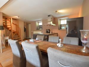 斯莱纳肯Stunning Holiday Home near Forest in Slenaken的厨房以及带木桌和椅子的用餐室。
