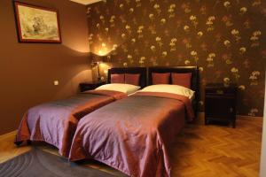 Liběchov利别霍夫旅馆的卧室内的两张床,配有花卉壁纸