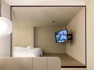 新加坡ST Signature Jalan Besar的一间卧室配有一张床和镜子内的电视