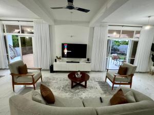 马林迪Mich Homes的客厅配有沙发、椅子和电视