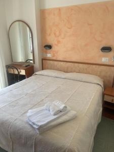 里米尼Hotel Tyc Soleti Hotels的床上有两条毛巾
