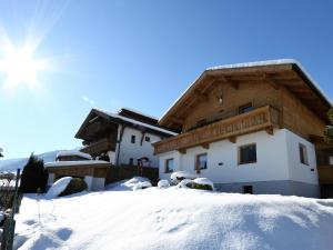 菲根Beautiful holiday home in a stunning location with sauna的雪覆盖的房子,后面有太阳