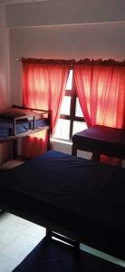 安蒂波洛Blue-Sky Wave的一间卧室配有床和红色窗帘的窗户