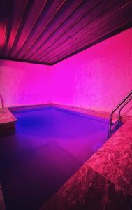 阿瓦诺斯萨克里窑洞旅馆的游泳池,室内有粉红色的灯光