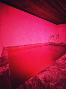 阿瓦诺斯萨克里窑洞旅馆的一间设有粉红色墙壁和两个衣架的房间