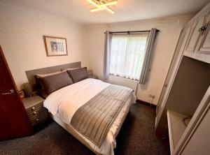 FlookburghSunshine Lodge Haven Lakeland的一间卧室设有一张床和一个窗口