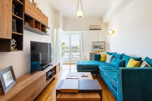 比雷埃夫斯Athens Luxury Getaway - Pasalimani City Oasis的客厅配有蓝色的沙发和电视