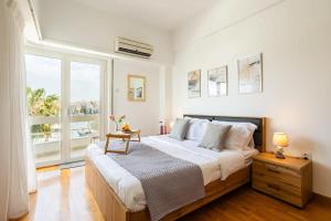 比雷埃夫斯Athens Luxury Getaway - Pasalimani City Oasis的一间卧室设有一张大床和一个大窗户