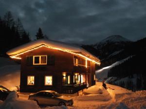 茵聂科里姆斯Beautiful and very luxurious chalet in walking and skiing area Innerkrems的雪覆盖着的房屋,里面装着灯