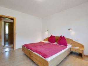 平茨高谷地霍勒尔斯巴赫Upscale Apartment in Salzburg with terrace and country views的一间卧室配有一张带红色枕头的大床
