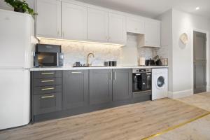 伍斯特WhiskAwayStays - Victoria House - Apartment 6的厨房配有灰色橱柜和白色冰箱