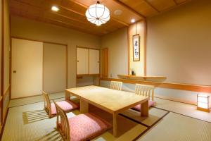 富士河口湖丸荣日式旅馆的一间带木桌和椅子的用餐室