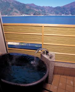 富士河口湖丸荣日式旅馆的带浴缸和盥洗盆的浴室