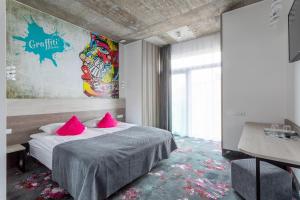 考纳斯阿尔基罗酒店的一间卧室配有带粉红色枕头的床