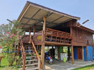 Ban KoYungthong Baan Suan Resort的大型木制房屋,设有大型甲板