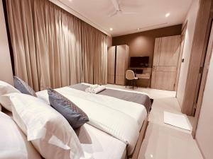 古尔冈The Lodgers Luxury Hotel Near Golf Course Road Gurgaon的酒店客房设有两张床和电视。