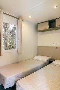 埃斯塔蒂特Camping La Sirena的小型客房 - 带2张床和窗户