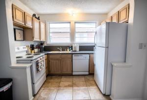 杰克逊维尔Charming Riverside Retreat 1 1 - Near 5 Points #4的厨房配有白色冰箱和木制橱柜。