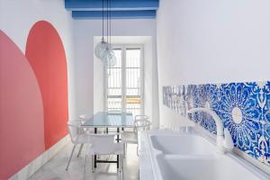 塞维利亚Magno Apartments Almirante Hoyos House的一间带桌子和两个水槽的用餐室