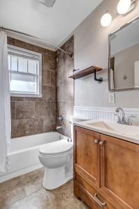 杰克逊维尔Cozy Retreat - Walkable to Bars & Restaurants的浴室配有卫生间、浴缸和水槽。
