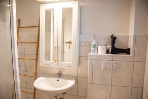 汉诺威Messeapartment für 4 Gäste mit kostenlosen Parkplätzen的一间带水槽和镜子的浴室